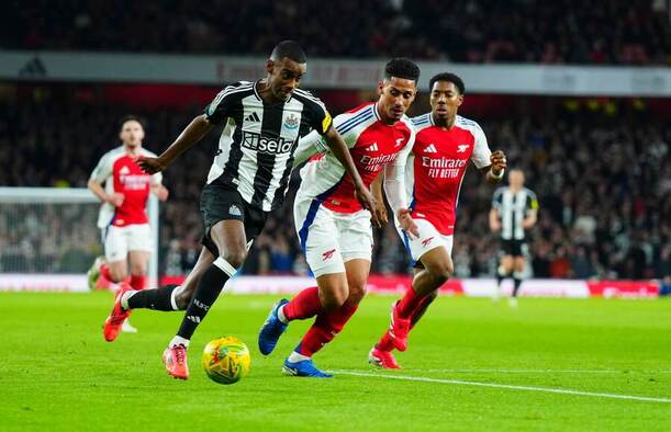 Alexander Isak z Newcastlu běží kolem Williama Saliby z Arsenalu