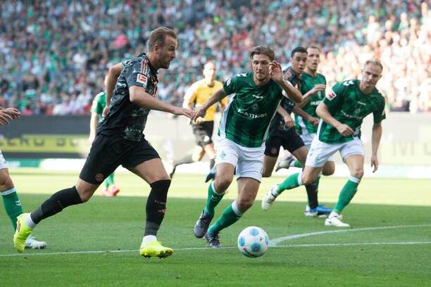 Harry Kane běží na bránu Brém. Uprostřed Niklas Stark.